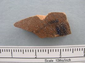 Rust/brown glazed crockery shard with blue marking on one side