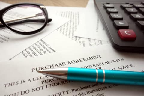Purchase agreement document for filling and signing on desk