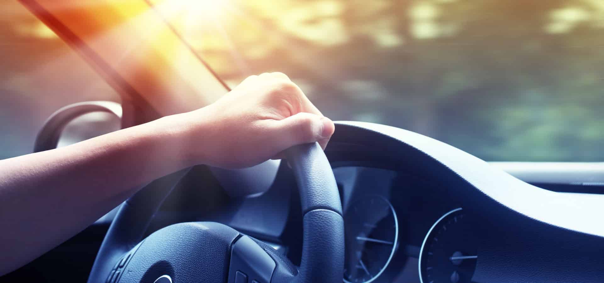 a hand holding a steering wheel