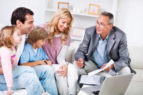 Family meeting with a man at computer with paperwork 