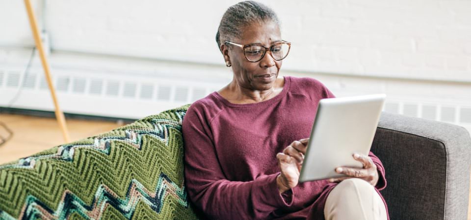 Woman using ipad while sitting on couch